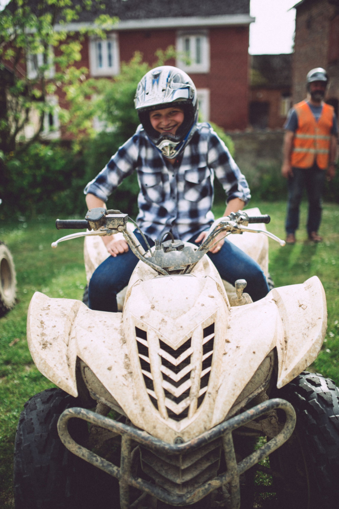 Enfant souriant sur un quad à la ferme